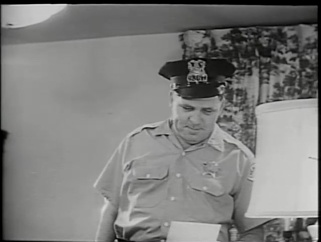 A policeman reads a suicide note.